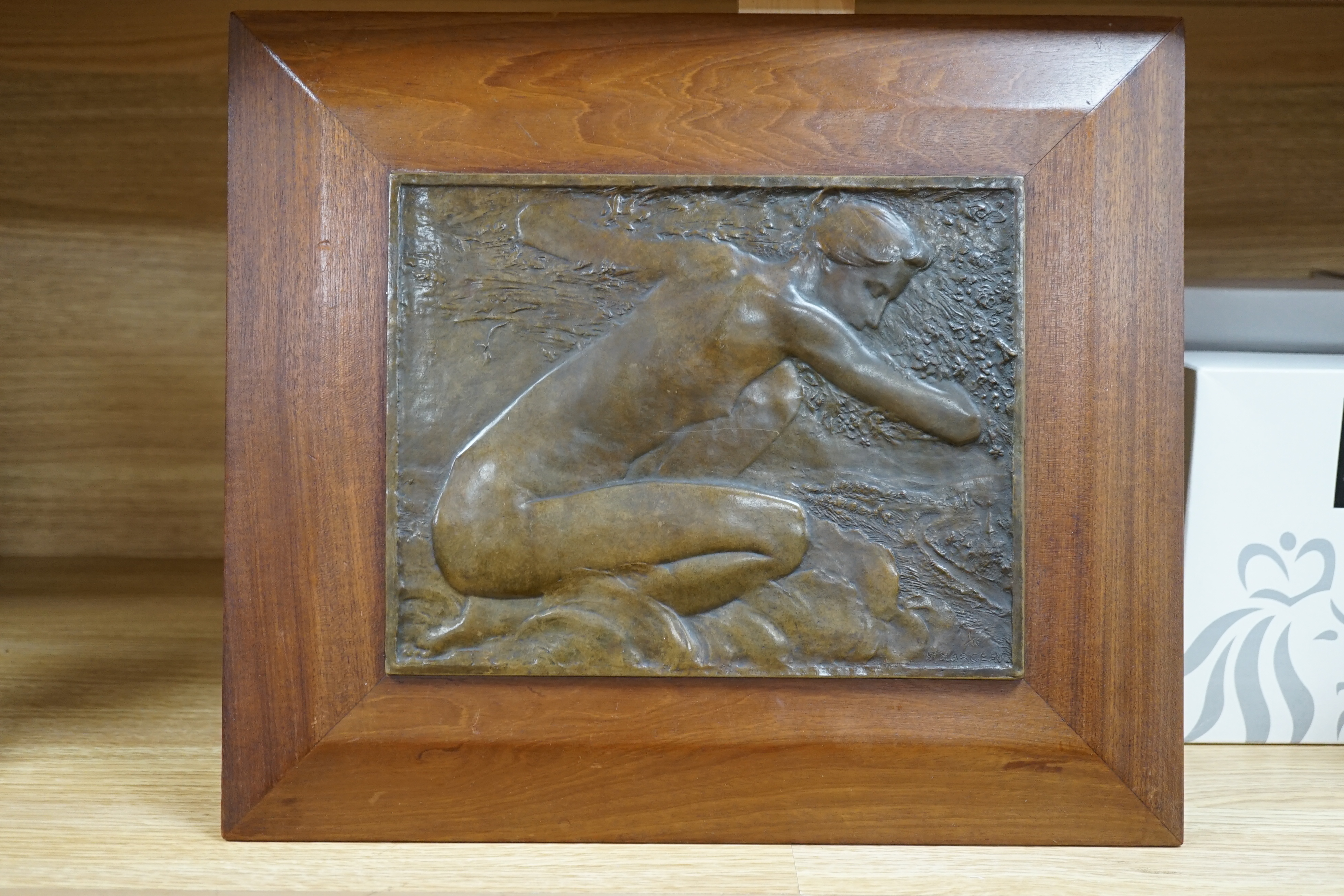 A framed bronze plaque of a kneeling figure, signed lower right, St. Marceau, limited edition 1/10, 31cm high. Condition - good